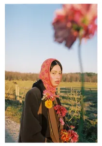 Close-up of pink floral knit balaclava and black scarf with autumn wool coat