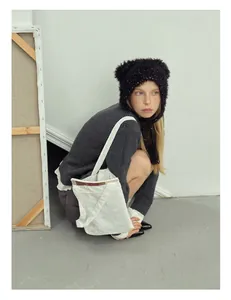 Fashionable black faux fur earflap hat with colorful dots and matching white canvas bag