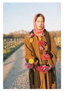 Detail of pink floral jacquard balaclava hood with brown wool coat and red gloves