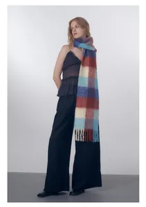 Close-up of wool blend gradient plaid scarf with long fringe details in cold studio