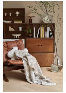 Detail of Nordic leaf pattern knitted throw blanket on a brown leather armchair