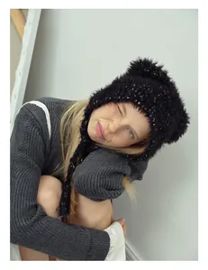 Detailed texture of black plush knit beanie featuring vibrant rainbow decorative threads