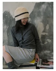 Detail einer weichen gestreiften Webpelz-Mütze kombiniert mit einem herbstlichen Strickoutfit