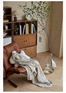 Detail of Nordic jacquard knit blanket with brown stripes on a leather chair