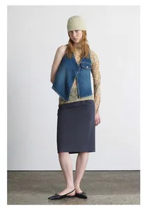 Modische dunkelblaue asymmetrische Jeansweste kombiniert mit braunem geometrischem Netztop