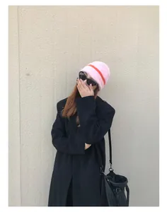 Detailansicht der rosa und orange gestreiften Webpelz-Strickmütze für Damen im Winter