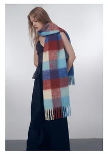 Close-up of thick gradient plaid scarf with soft wool blend texture and tassel fringe