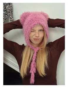 Detailed close-up of pink faux fur beanie featuring cute bear ears and long tassel ties