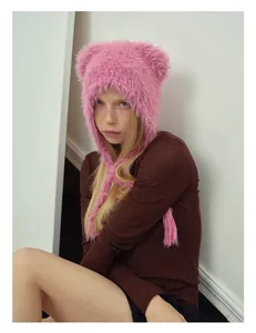 Close-up of pink faux fur bear ear hat with long straps and fluffy texture details