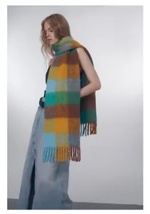 Detail of wool blend gradient plaid scarf featuring long tassels and soft mohair texture