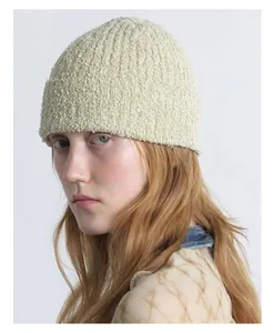 Detailaufnahme der weichen hellgrünen Strickmütze aus Bouclé für Damen im Winter