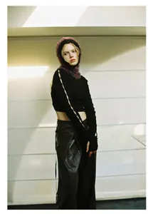 Detail of a purple textured knit balaclava styled with a black cutout crop top for Y2K look