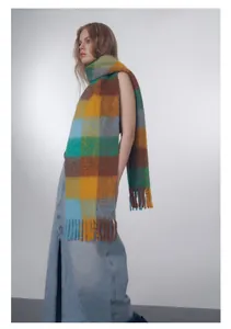 Detail of colorful gradient checkered wool blend scarf featuring thick fringe tassels