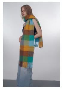 Close-up of vibrant gradient checkered wool blend scarf with decorative long fringes