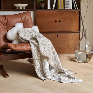 Nordic artistic knitted blanket with abstract leaf pattern in cream and brown tones