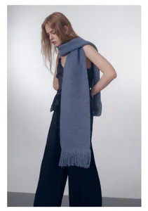 Dettaglio della sciarpa in maglia a coste blu nebbia con frange di nappe fitte