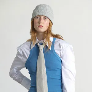 Hellgraue Strickmütze aus strukturiertem Bouclé-Garn, getragen von einem Model im Minimal-Stil
