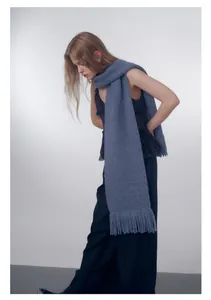 Dettaglio di morbida sciarpa in maglia con frange in elegante blu-viola Morandi