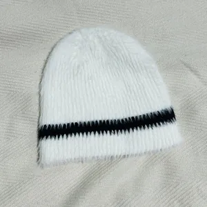 Nahaufnahme der flauschigen weiß-schwarz gestreiften Strickmütze aus Kunstpelz-Mix