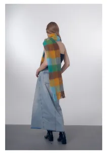 Close-up of wool blend gradient plaid scarf featuring long fringes and soft texture
