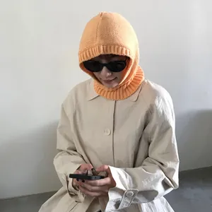 Pasamontañas de punto naranja con diseño acanalado combinado con gabardina elegante