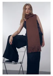 Sciarpa marrone a maglia grossa con frange indossata da una modella in studio