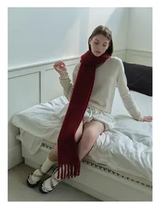 Close-up of deep wine red wool blend scarf with long tassels and soft knit texture
