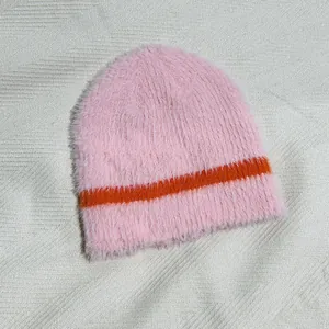 Detail der flauschigen Kunstmarder-Struktur und der rosa-orange gestreiften Strickmütze