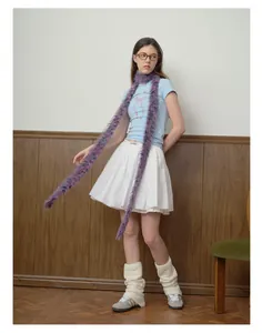 Modella che indossa una lunga sciarpa in finta pelliccia viola con gonna a pieghe