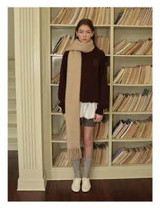 Chic beige wool blend knit scarf with fringe styled with a brown collegiate sweatshirt