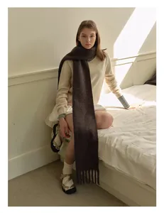 Detail of a thick dark brown wool blend knit scarf with premium tassel fringe edges