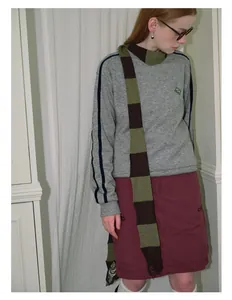 Detail of a striped knit scarf paired with a grey sweatshirt for a stylish autumn look