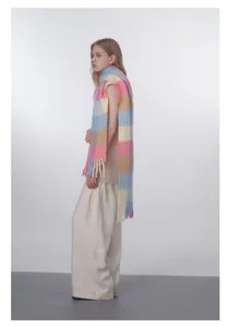 Detailed view of fluffy pastel plaid wool scarf with long decorative fringe tassels
