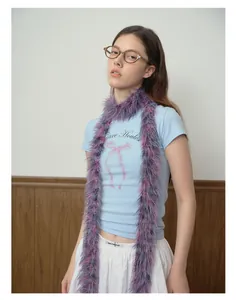 Dettaglio di una sciarpa in finta pelliccia viola e rosa abbinata a una T-shirt con fiocco