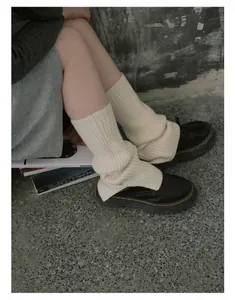 Detail of cream cable knit leg warmers with cozy slouchy texture for Y2K style