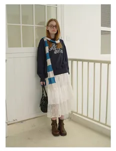 Detail of blue and white striped knit scarf paired with navy sweater and lace skirt