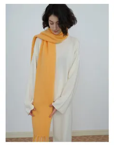 Close-up of bright yellow wool blend knit scarf with soft brushed texture and fringe trim