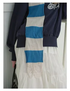 Close-up of blue striped wool blend knit scarf with distressed fringe and ripped details