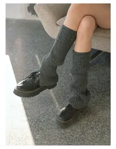 Detailed knit texture of dark grey wool blend leg warmers with black platform shoes