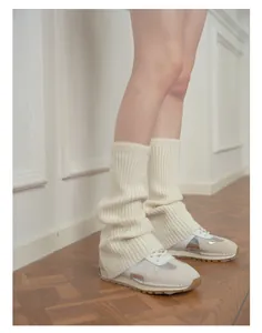Close-up of cream wool blend ribbed leg warmers with y2k style worn over sneakers