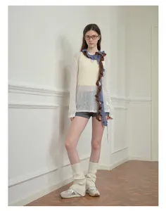 Detalle de bufanda con volantes azul y marrón con trenzas en espiral y flecos a mano