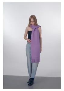 Dettaglio della sciarpa in maglia lilla con lunghe frange e consistenza soffice