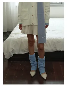 Dettaglio degli scaldamuscoli in maglia di qualità con accessori autunnali coordinati