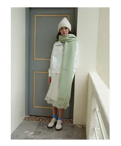 Gletscherblauer Wollschal mit Fransen an einem Model in einem stilvollen Winteroutfit