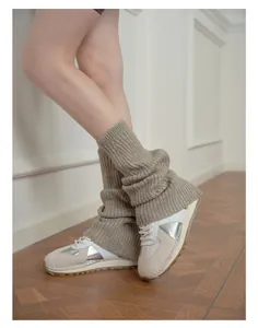 Close-up of gray wool blend ribbed leg warmers styled with stylish leather sneakers