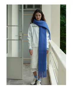 Nahaufnahme des gletscherblauen Wollschals mit grobem Strickmuster und langen Fransen
