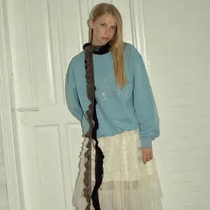 Sudadera azul y falda de tul blanco con una bufanda de volantes de lana mohair gris