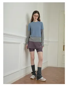 Close-up of grey knit leg warmers paired with chunky retro sneakers for Y2K street style
