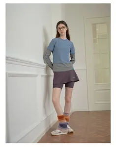 Dettaglio di scaldamuscoli soffici sfumati abbinati a gonna corta e scarpe sportive