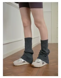 Close-up of charcoal grey ribbed wool blend leg warmers with retro sneakers in Y2K style